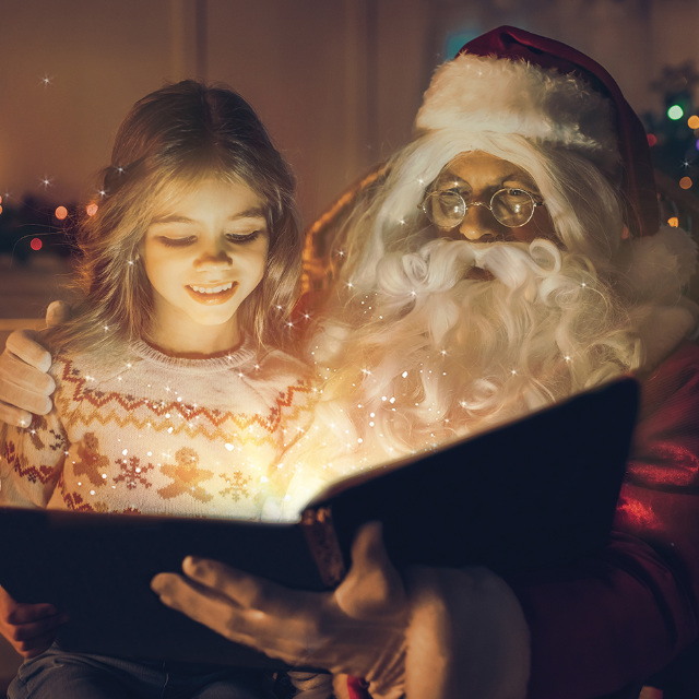Weihnachtsmann liest mit einem Mädchen